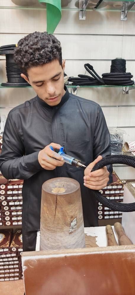 شاب يقوم بصيانة «العقل» وتعطيرها في أحد الأسواق بجدة.(عكاظ)