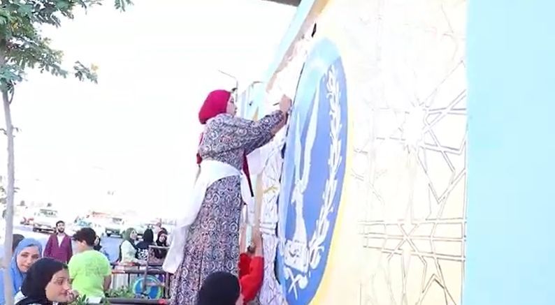طالبة تشارك في رسم الجداريات بكفر الشيخ
